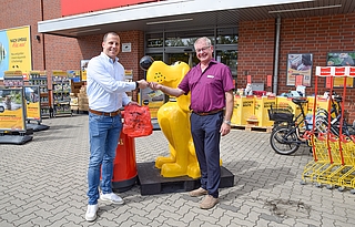 Jörg Schmidt-Hilger (rechts) von der Stadt Elmshorn überreicht einen Schlüssel für Beutelspender an Eike Fabian Möller, Leiter des Filialmanagements von Das Futterhaus, der die Tüten bereits parat hat. (Foto: Frank)