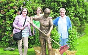 Fröhliche Siegerehrung: Tanja Stendorf (links) und Anna-Ilse Wehner (rechts) hatten vorgeschlagen, die Gärtnerin-Skulptur Rosalie zu nennen. Ihre Idee setzte sich durch. Stefanie Schmedes vom Förderverein des Rosariums beschenkte sie mit Rosenstauden. Unsere Leser tauften vor einem Jahr bereits die Skulptur Heiko. (Foto: Frank)