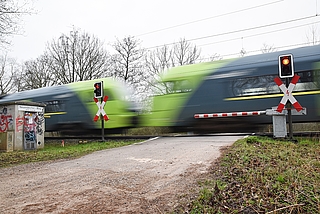 Ein Zug rauscht durch den Bahnübergang Neuendeicher Weg. Auf dieser Strecke fallen im Juli viele Verbindungen aus. (Archiv: Frank)