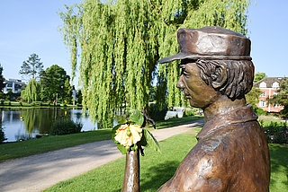 Eine echte Rose ersetzt die Bronze-Blume in der Hand der Gärtner-Skulptur im Rosarium. (Foto: Frank)