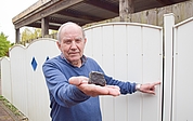 Wilfried Labusch zeigt den Meteoriten und die Stelle, an der das außerirdische Gestein seinen Metallzaun beschädigte. (Foto: Frank)